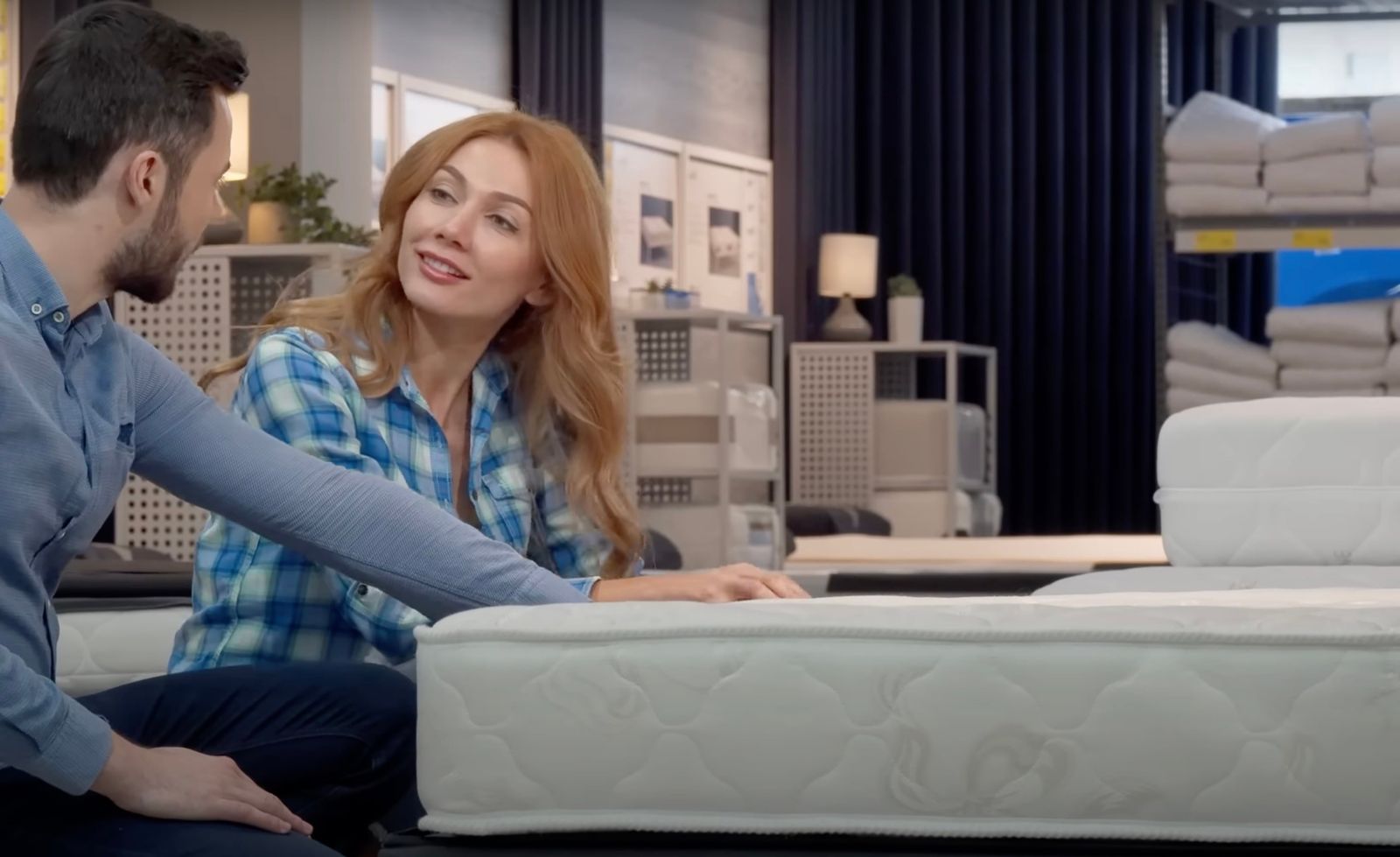 Couple sitting on a new mattress in a showroom